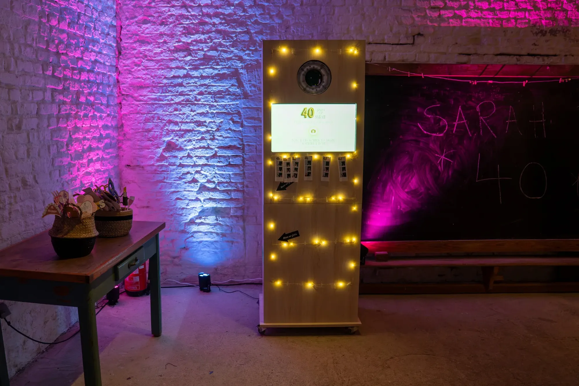 The Motion Box photo booth with fairy lights in a venue lit in purple