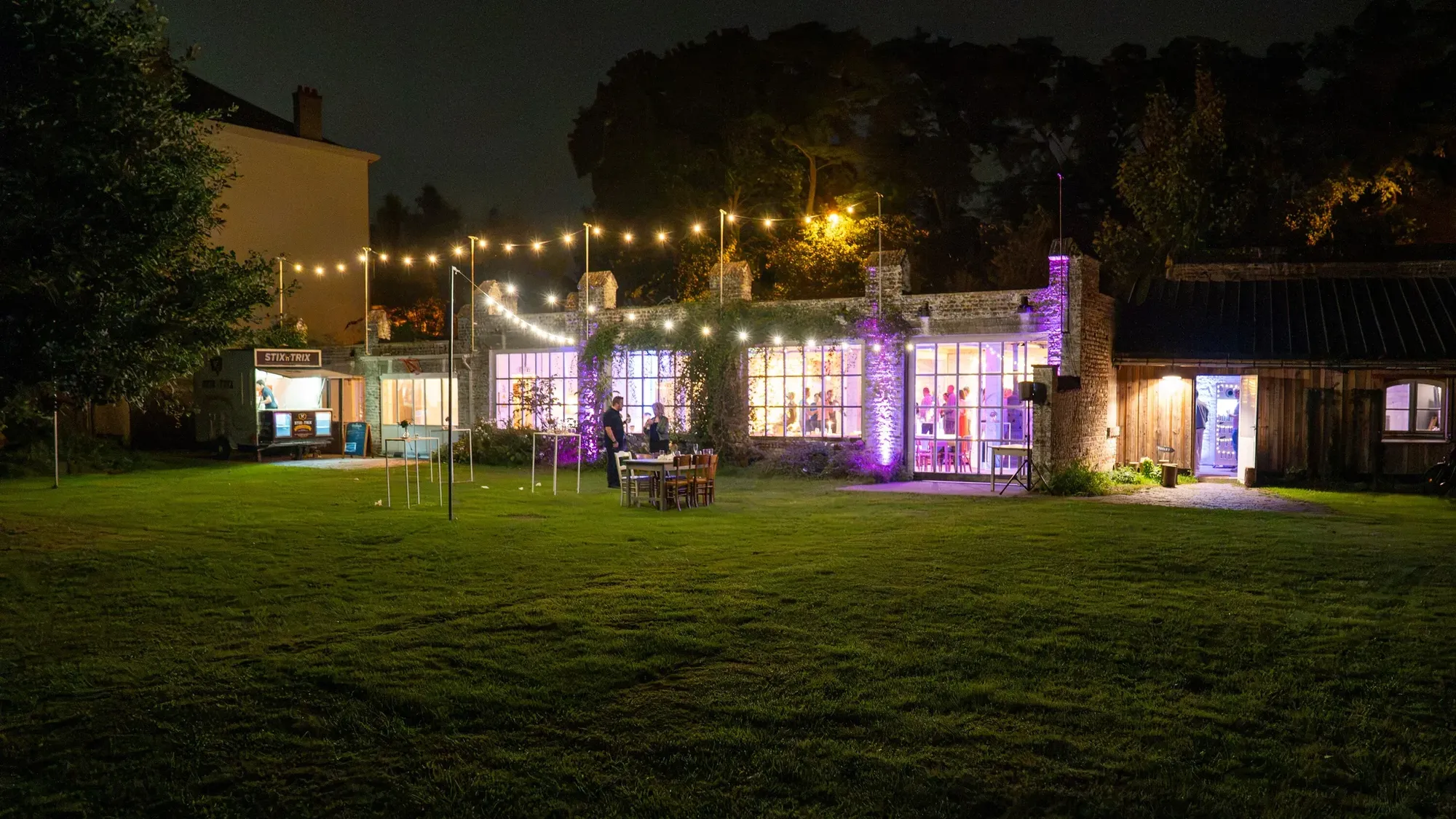 Party venue with a garden and string lights on a summer evening